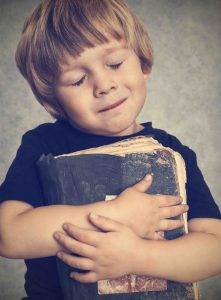 boy hugging book